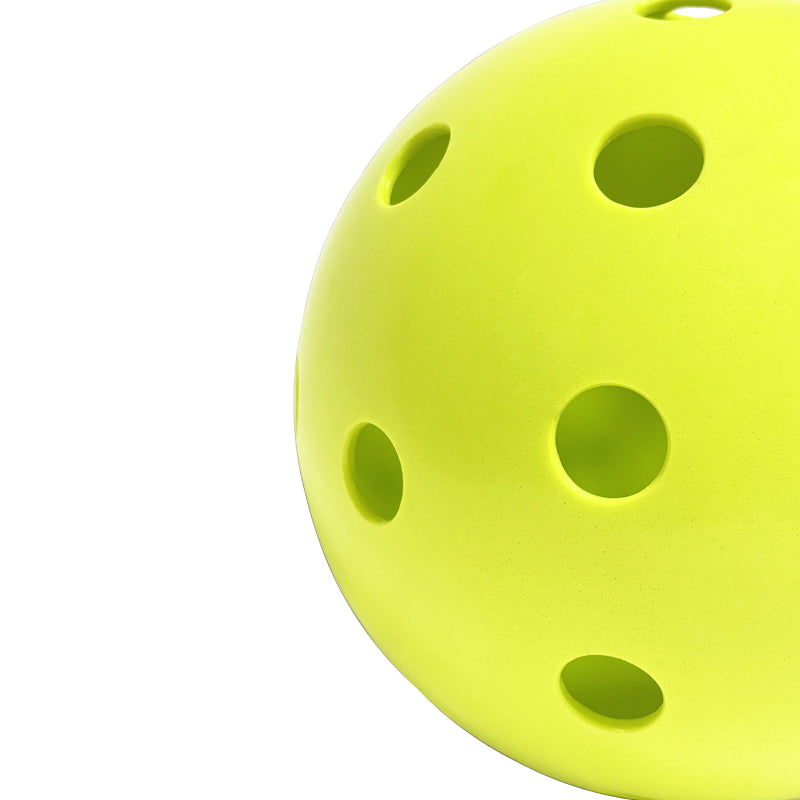 Perforated Surface of Chartreuse Pickleball Against a White Background 