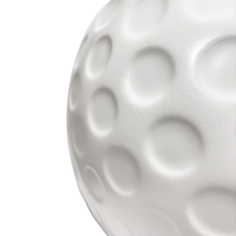 The Dimpled Surface of a Giant Plastic Golf Ball Against a White Background