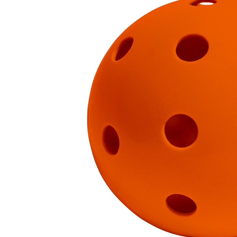 Perforated Surface of Color Pickleball Against a White Background