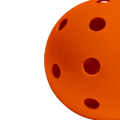 Perforated Surface of Color Pickleball Against a White Background